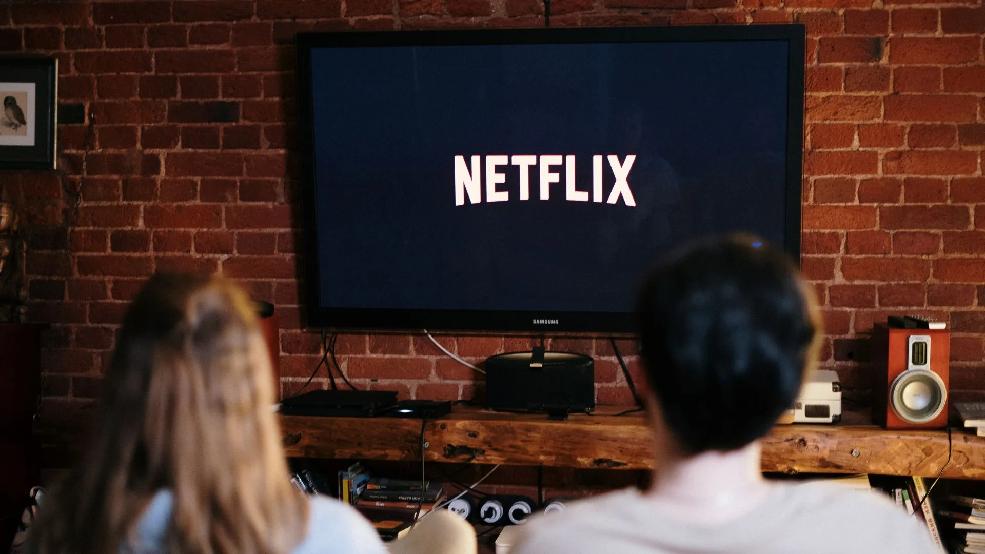 Pareja viendo películas de risa en Netflix en la sala de su casa