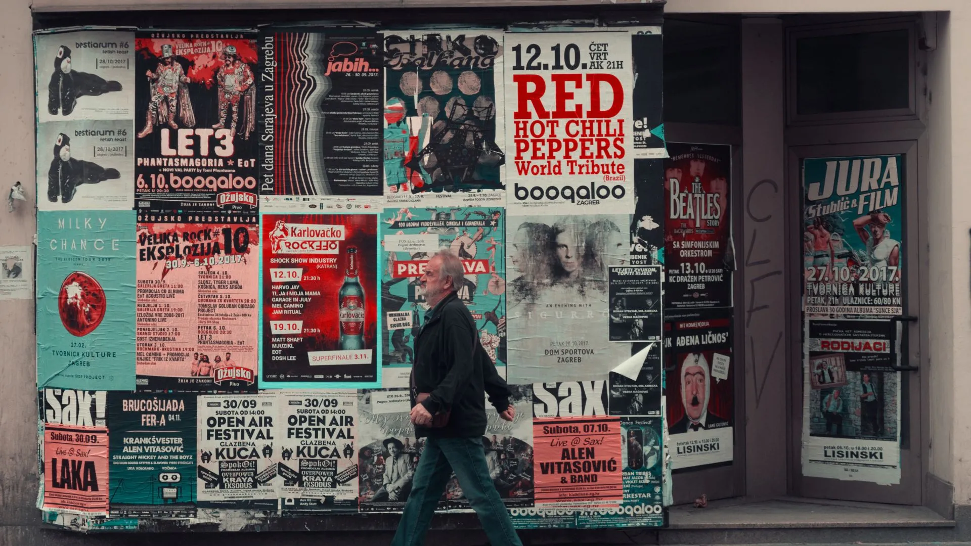 Qué es la publicidad representada en una pared llena de carteles antiguos, símbolo del origen y evolución del mensaje publicitario.