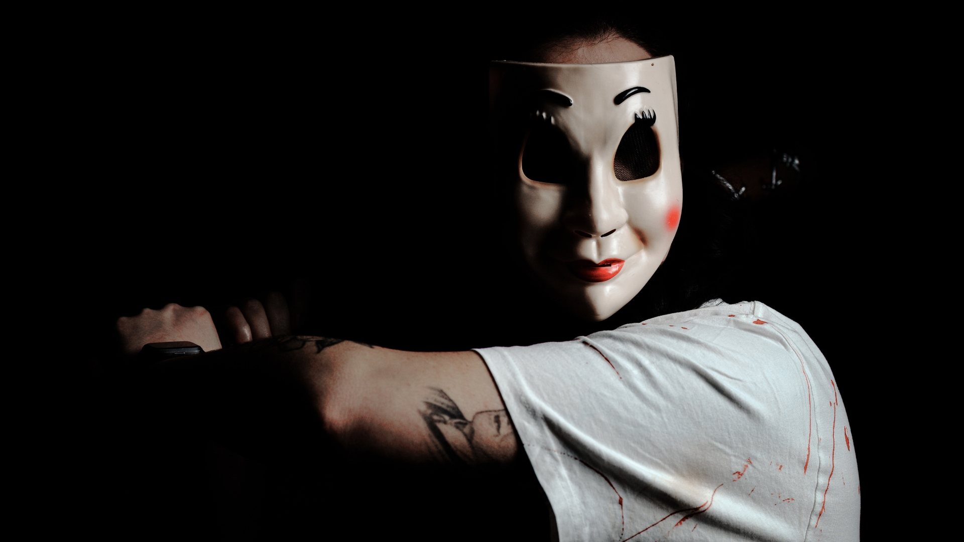 Persona con máscara blanca sosteniendo un cuchillo en la oscuridad, imagen representativa de una recomendación de películas de terror para ver en streaming.