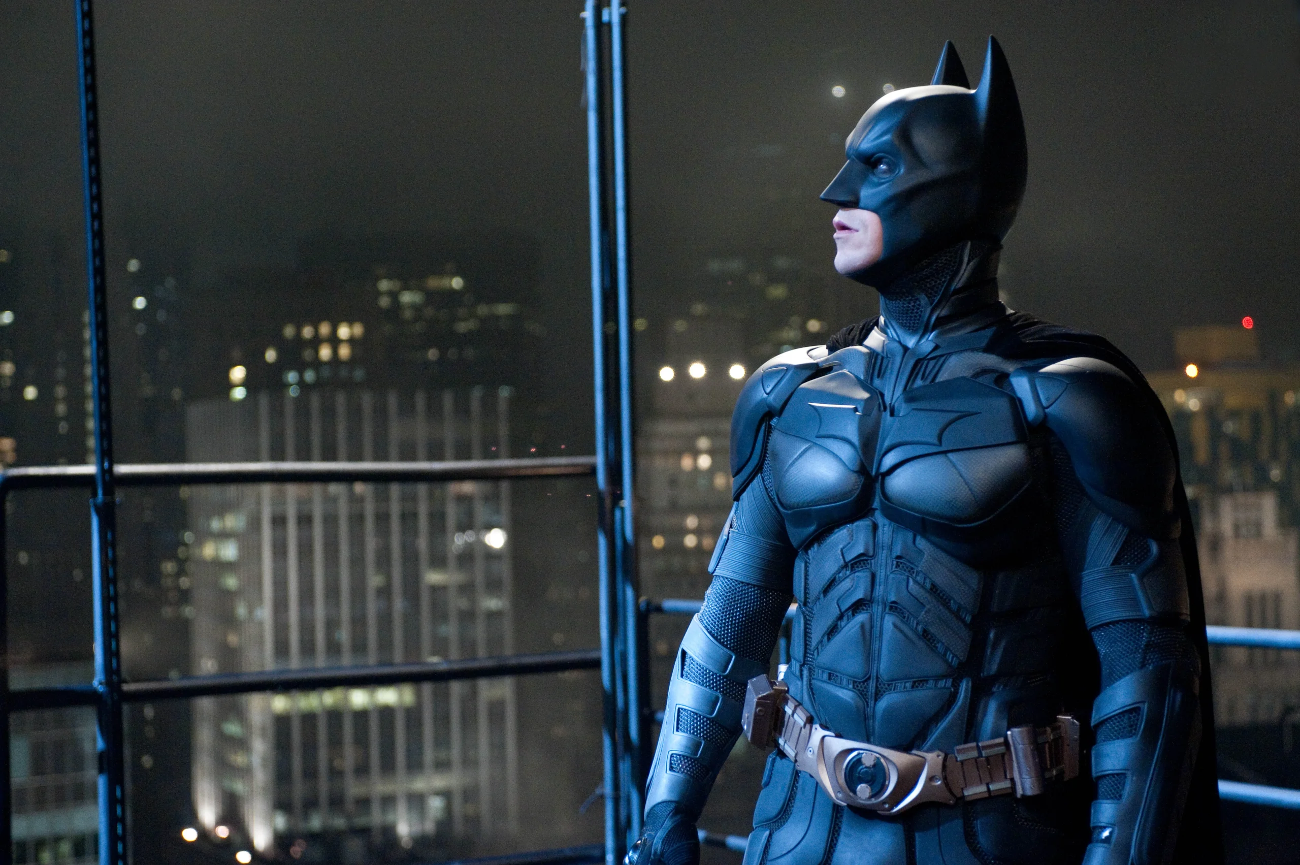 Batman frente al horizonte nocturno de Ciudad Gótica en una de las películas de super héroes en Netflix más reconocidas.