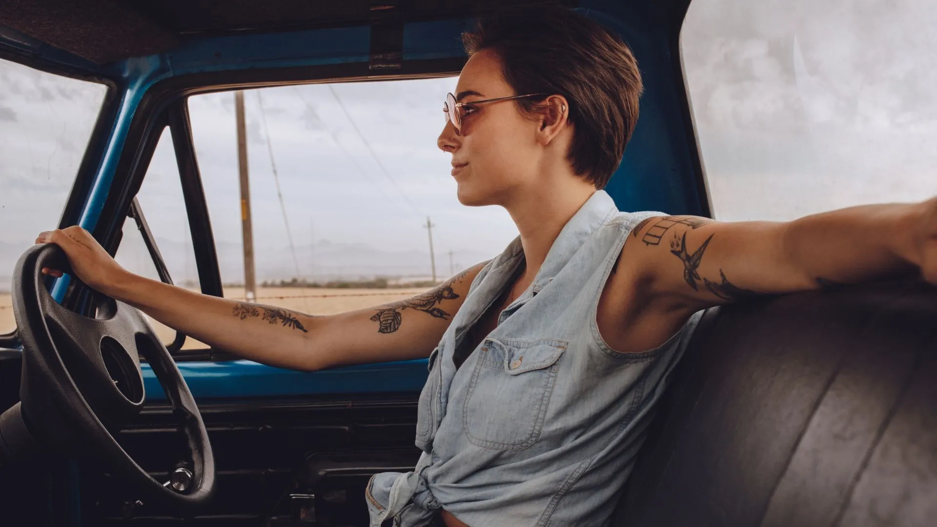 publicidad de autos mostrando a una mujer conduciendo un automóvil clásico en carretera abierta