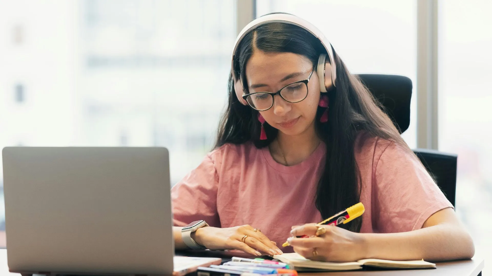 Estratega de marketing trabajando en su plan de comunicación frente a una laptop con auriculares.