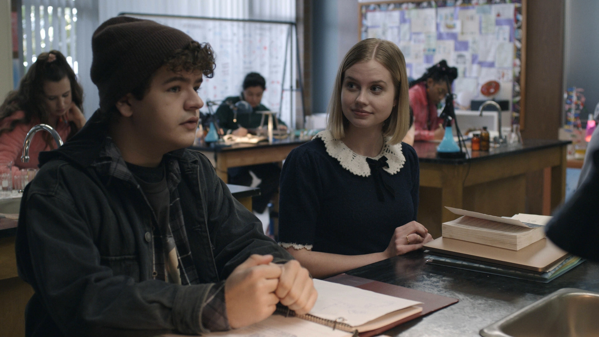 Dos estudiantes conversando dentro de un salón de clases en una escena de la película Honor Society (2022).
