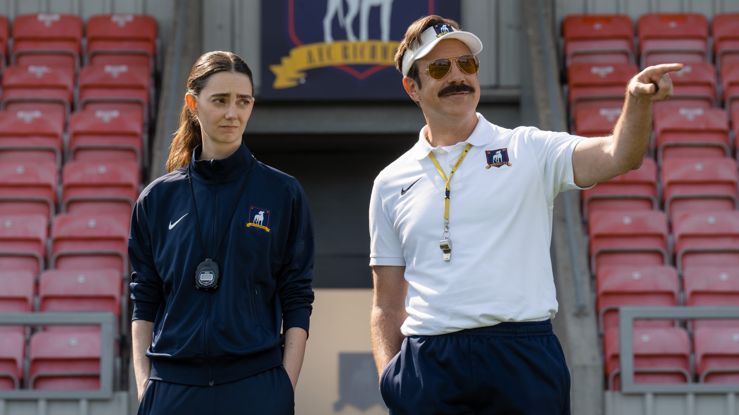 Dos entrenadores de futbol en un estadio, imagen relacionada con series de deportes como Ted Lasso.