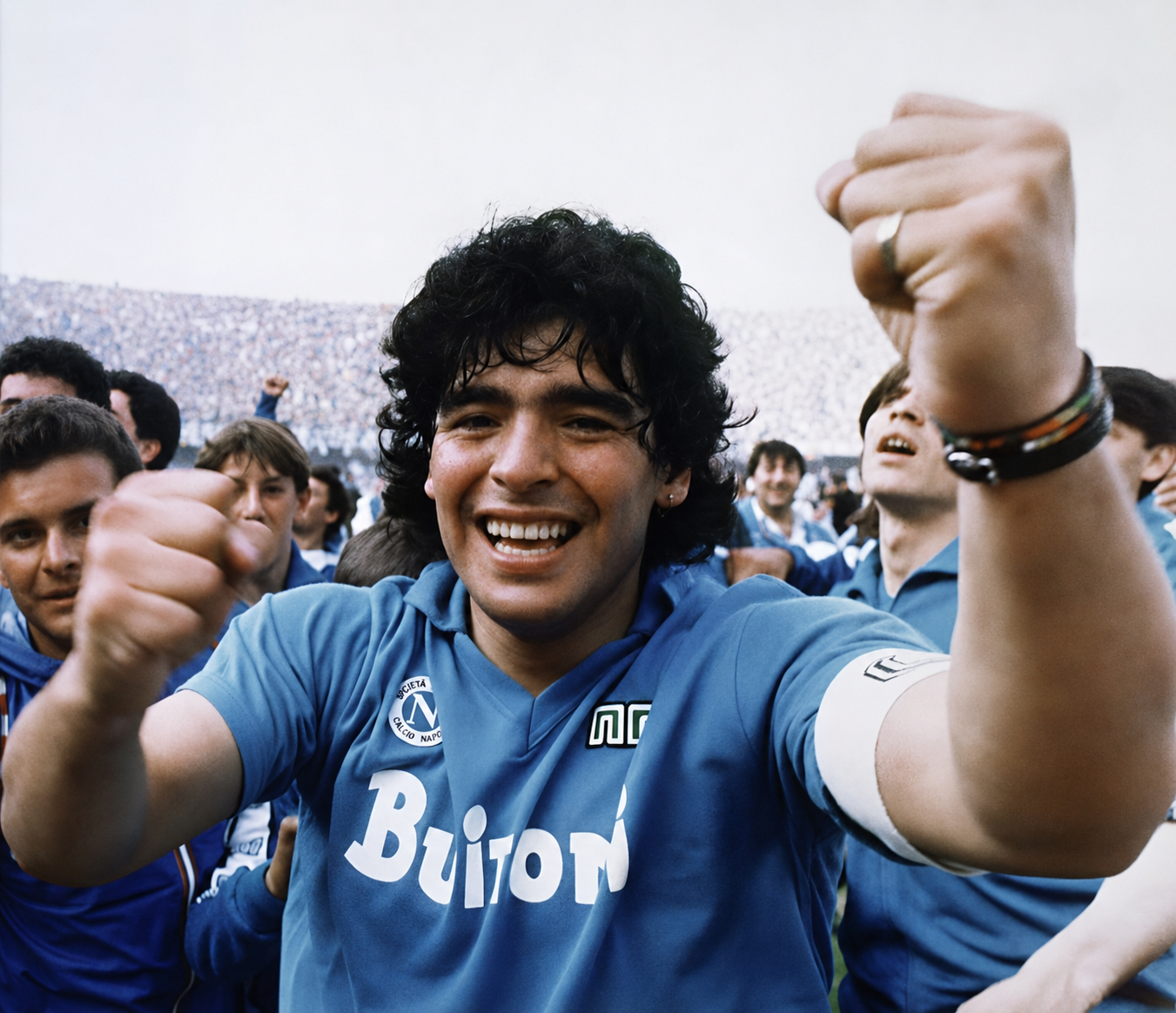 Diego Maradona celebra con la camiseta del Napoli y el brazalete de capitán.