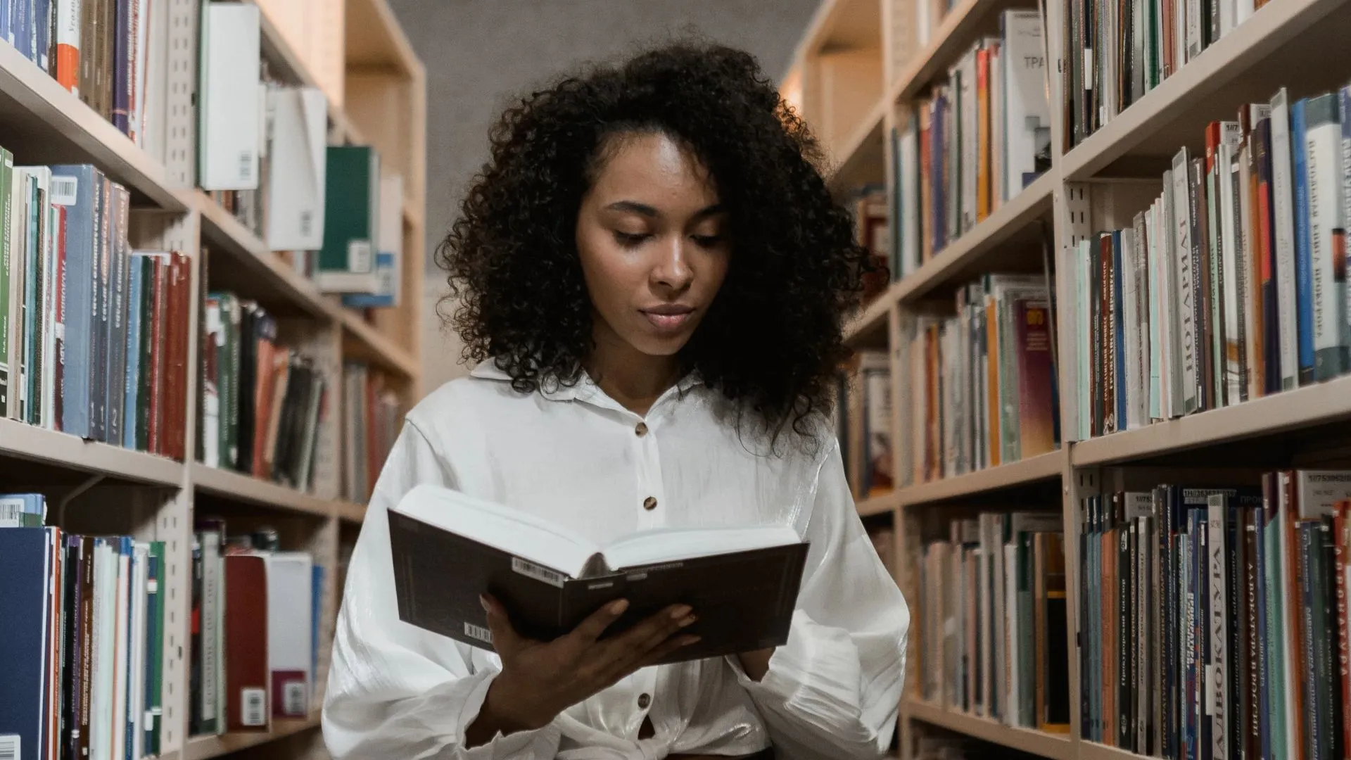 Mujer leyendo un libro de psicología en una biblioteca